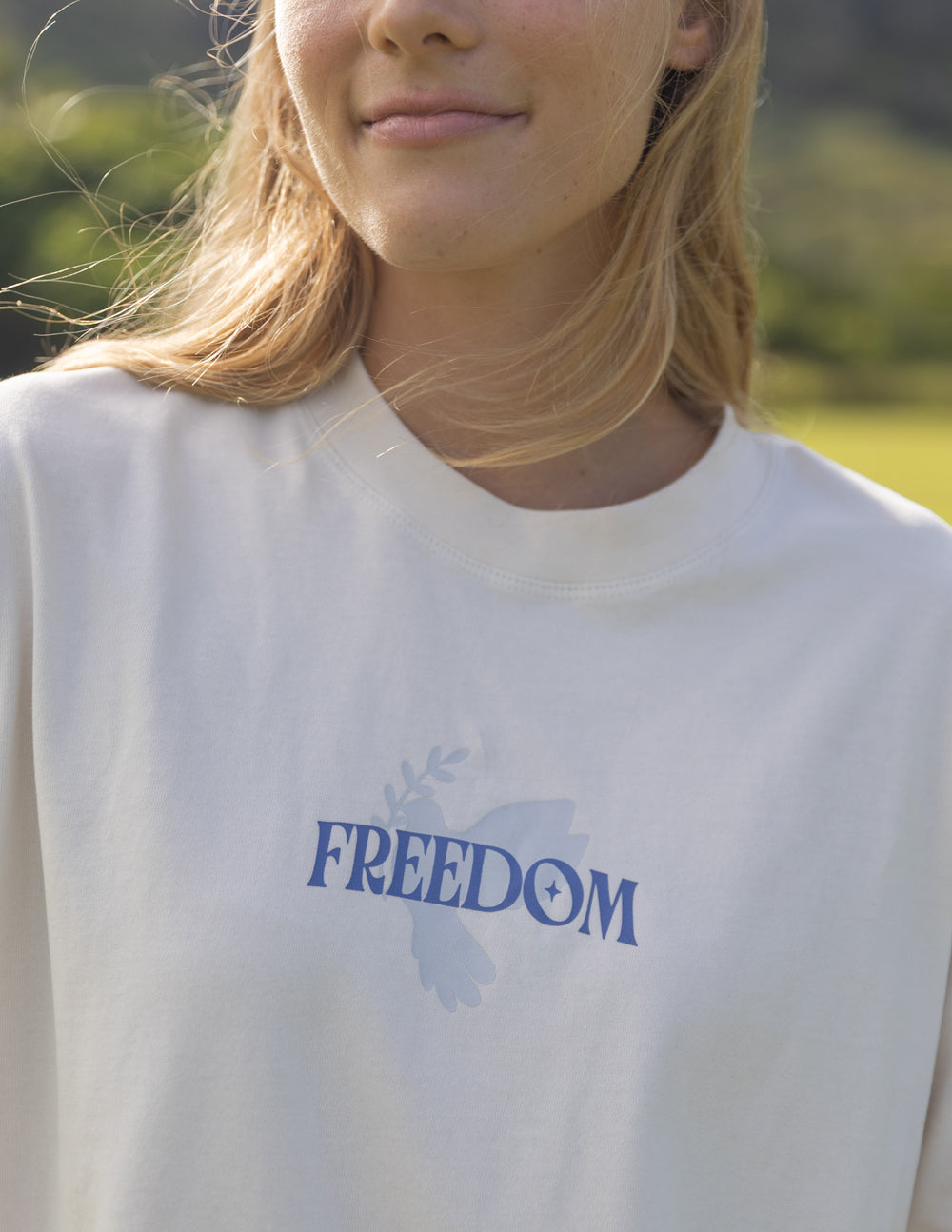 White unisex T-shirt with blue word "FREEDOM" on chest