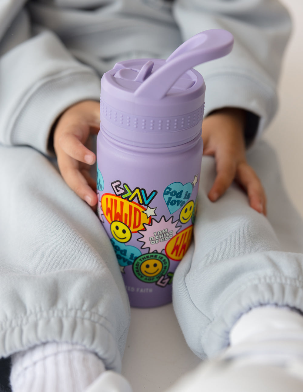 Lavender kids water bottle with sticker collage, close-up with flip spout detail