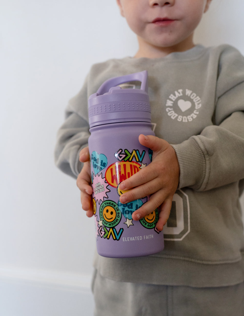 Lavender kids water bottle with sticker collage graphic, child holding it with both hands