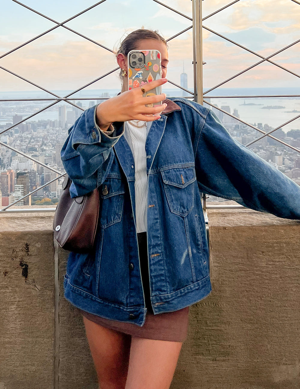 Phone case with colorful sticker collage artwork, light base, dual camera and flash cutouts