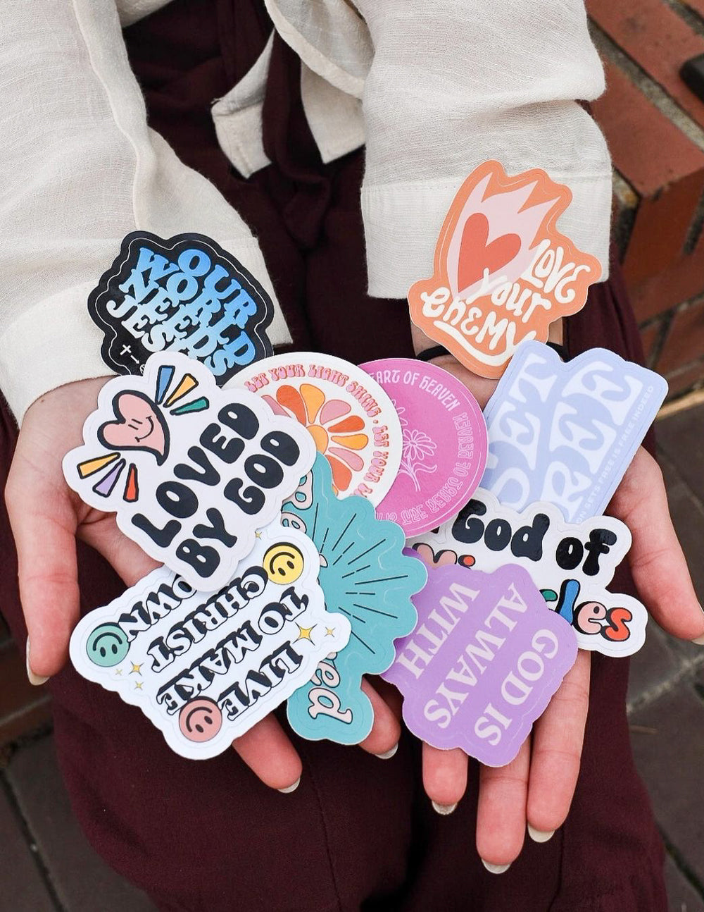 Assorted Christian stickers, including 'God of' hearts and colorful circular designs