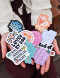 Assorted Christian stickers, including 'God of' hearts and colorful circular designs