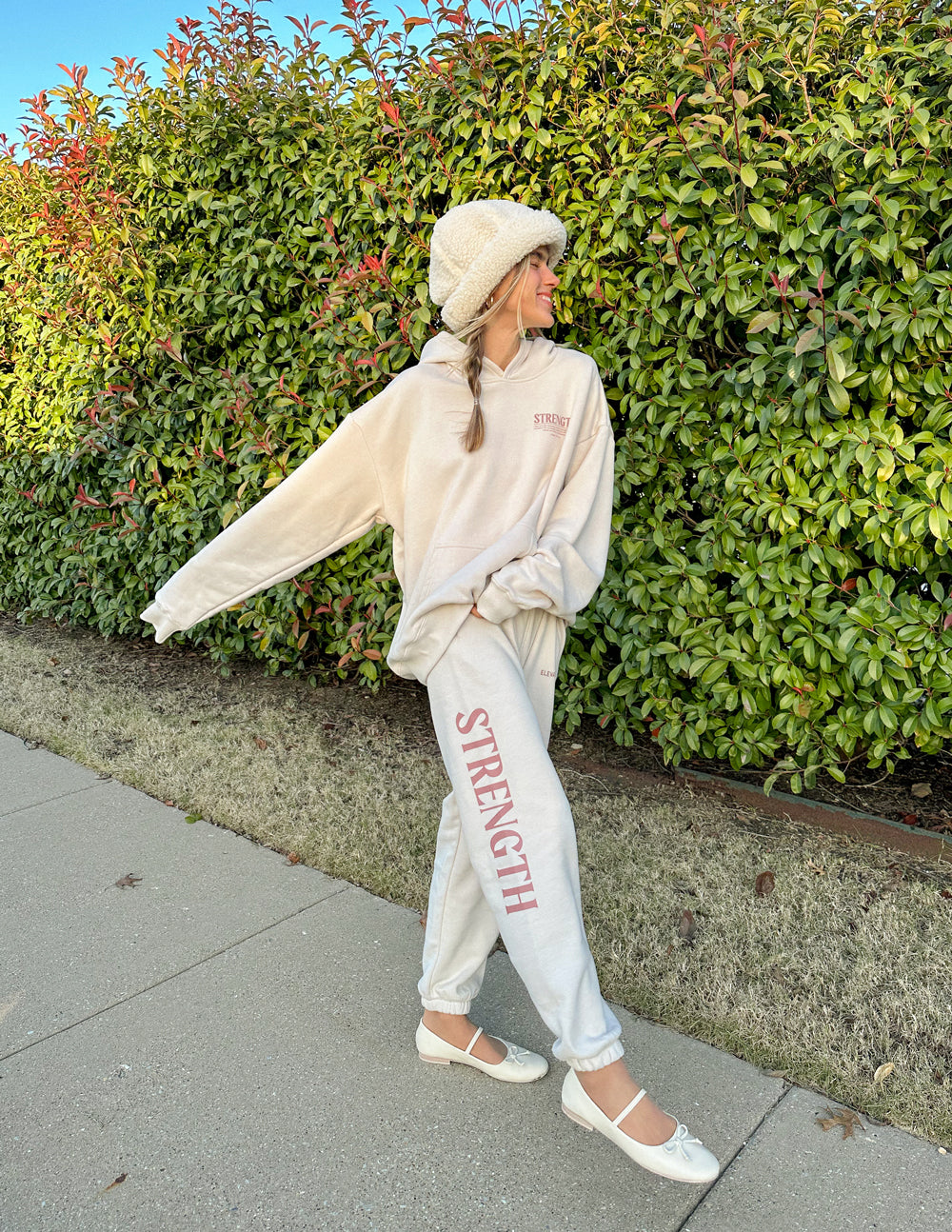 Cream unisex sweatpants with red STRENGTH vertical leg print and tapered elastic hem