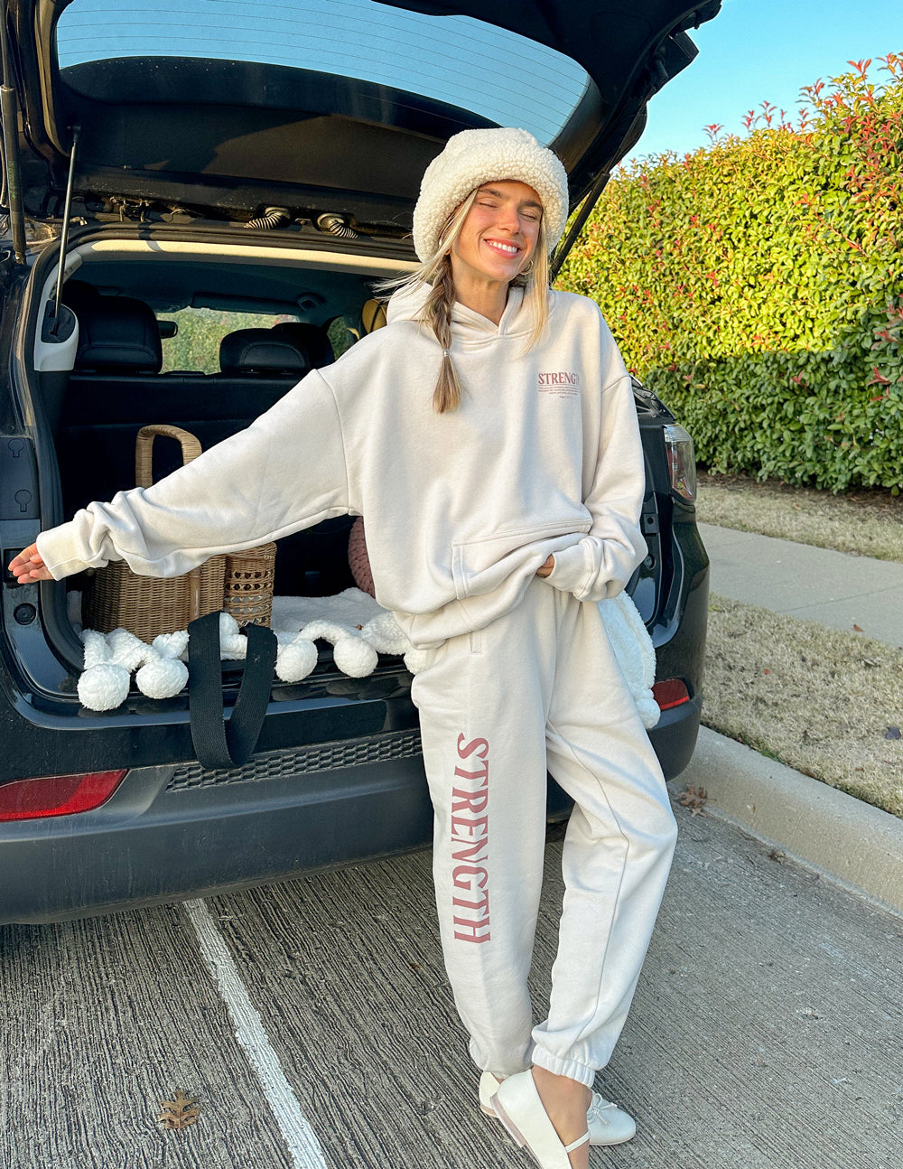 Cream unisex sweatpants with red STRENGTH side print, elastic waistband and ankle cuffs