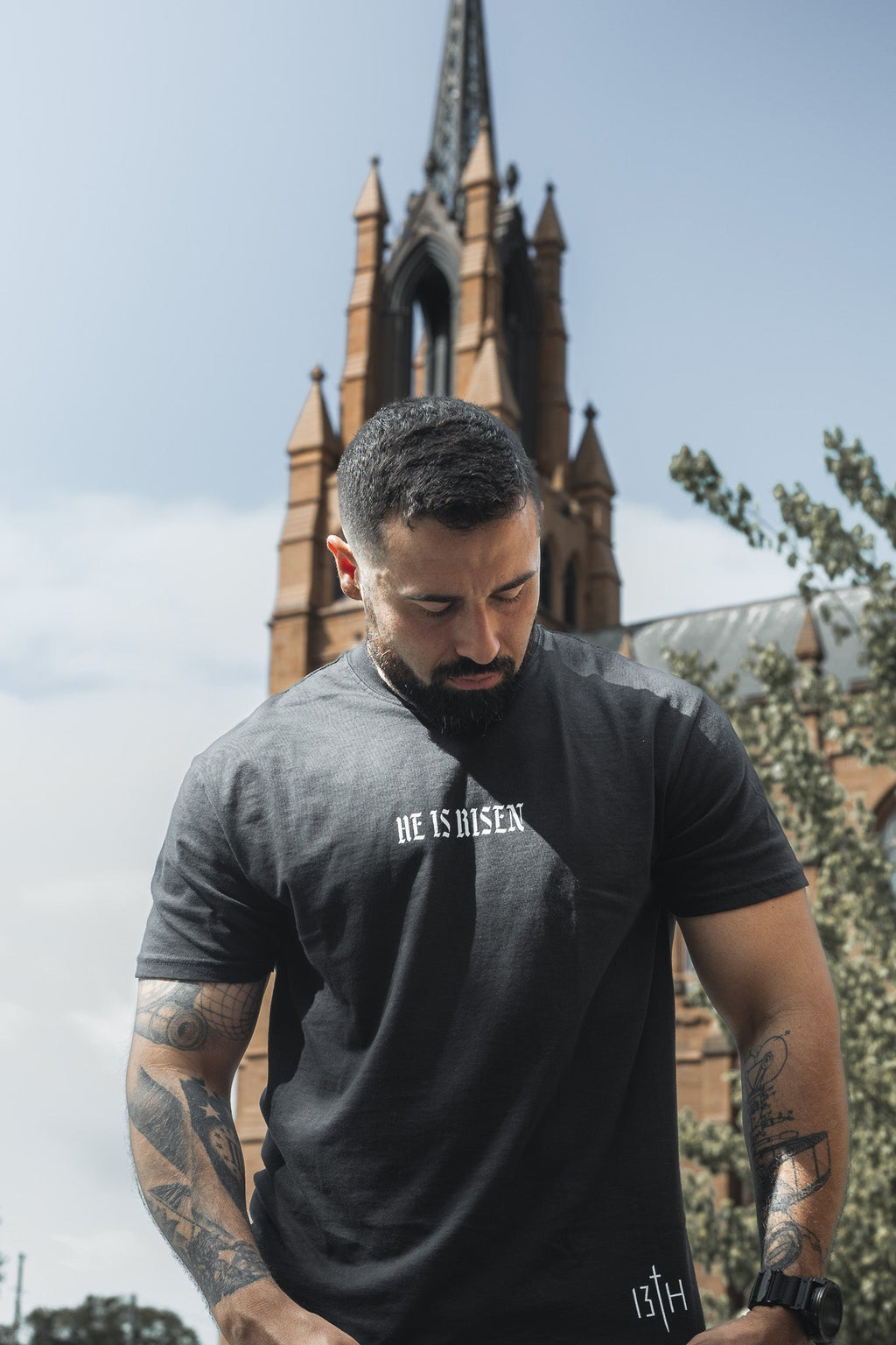 Black crew-neck t-shirt with “HE IS RISEN” front text