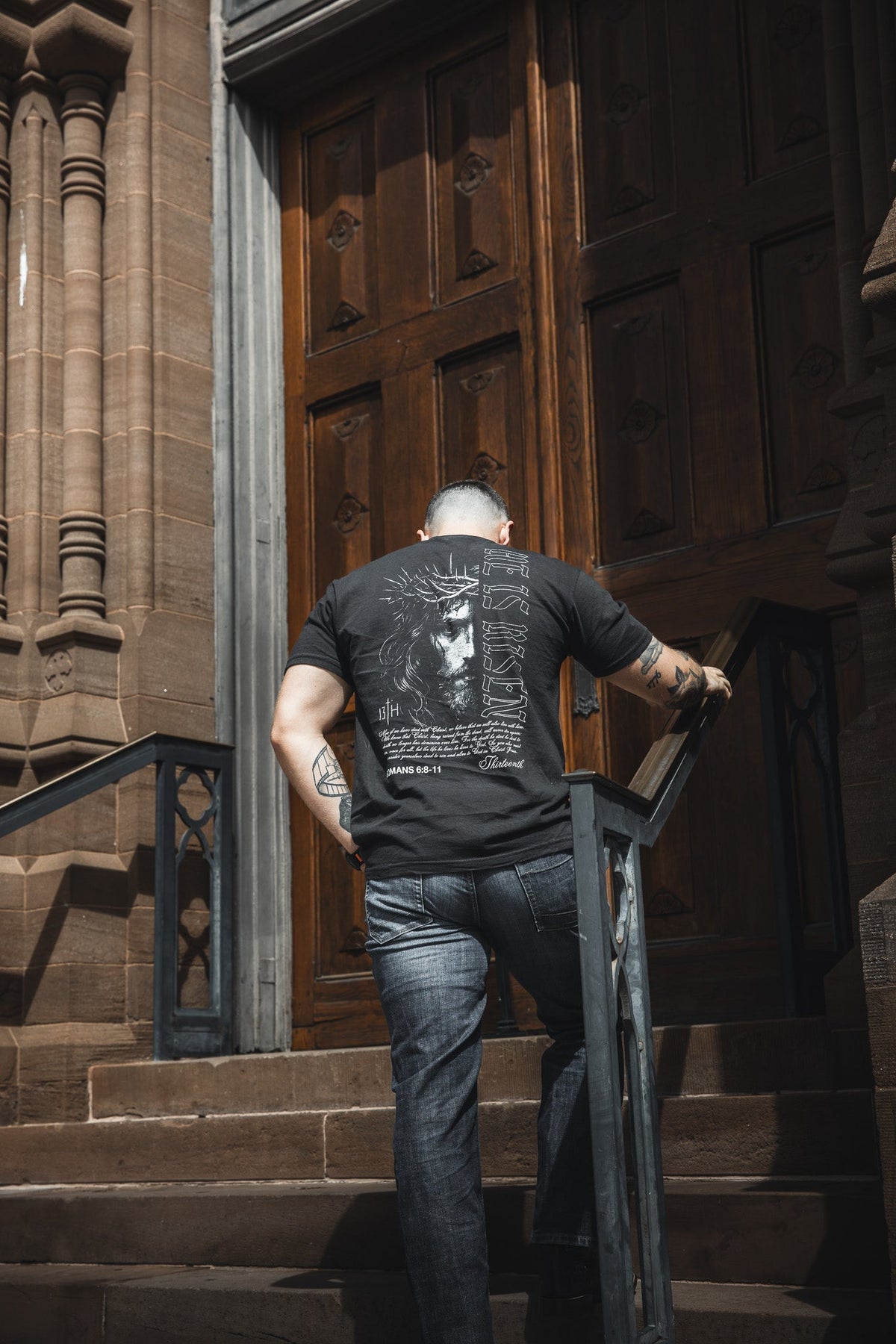 Black graphic t-shirt with large back portrait and scripture-style text