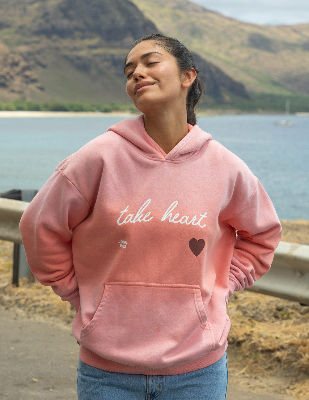 Pink unisex hoodie with 'take heart' script and heart graphic, front kangaroo pocket