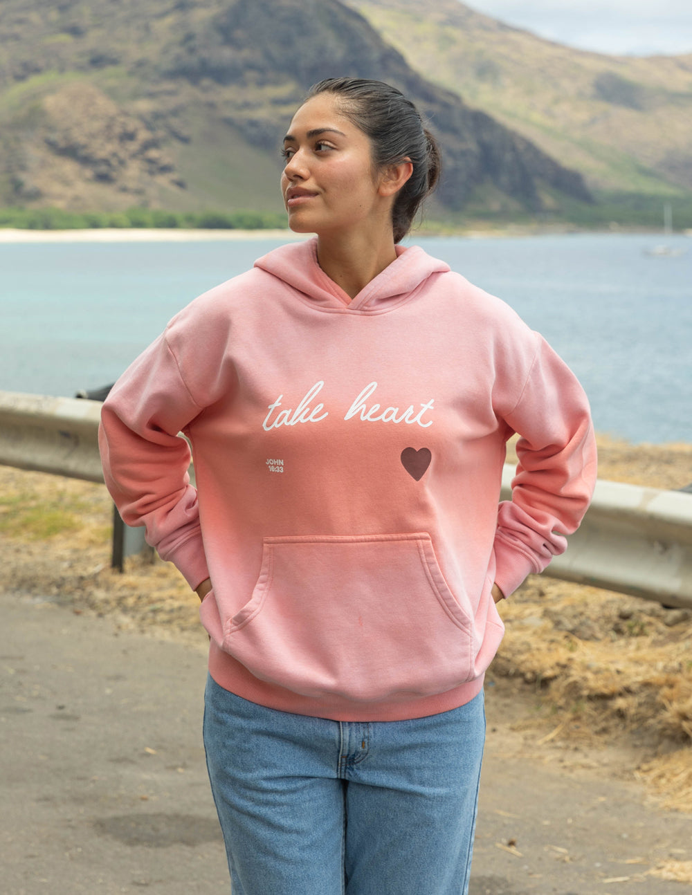 Pink unisex hoodie with 'take heart' script and heart print, front view