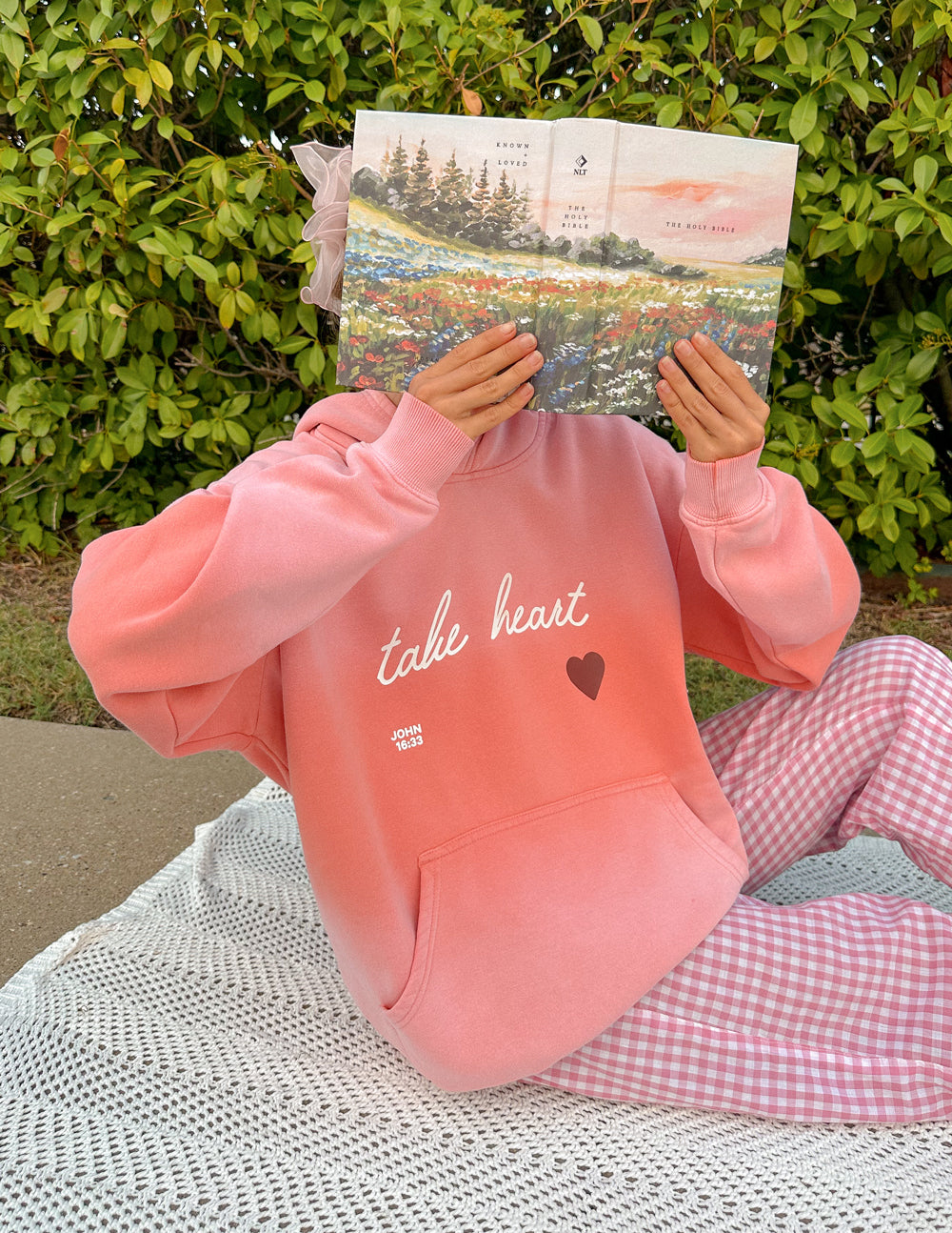 Pink unisex hoodie with 'take heart' script and heart graphic, front kangaroo pocket