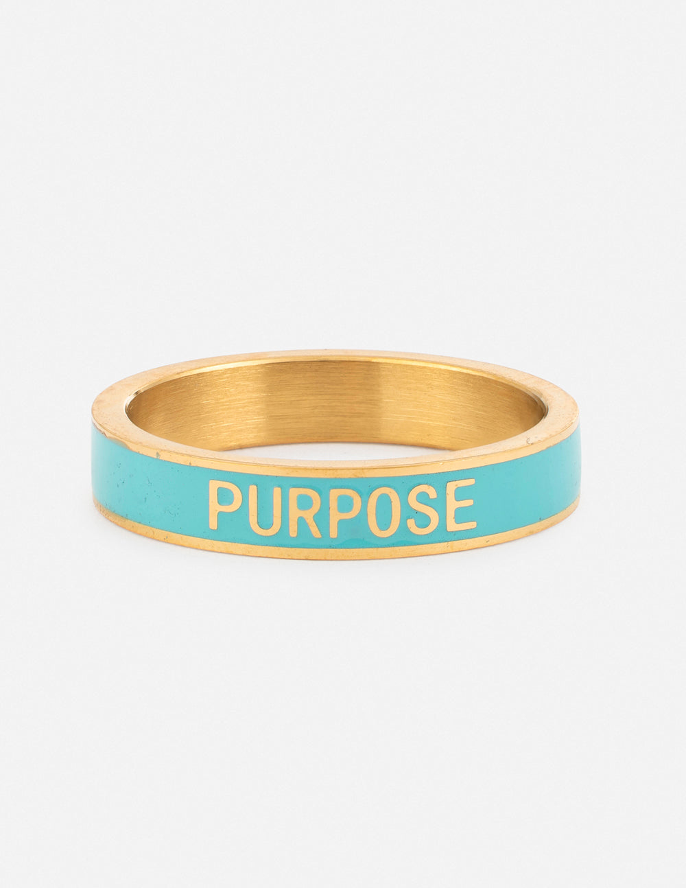 Teal enamel purpose ring with gold band and engraved “PURPOSE” lettering