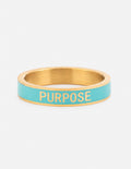 Teal enamel purpose ring with gold band and engraved “PURPOSE” lettering
