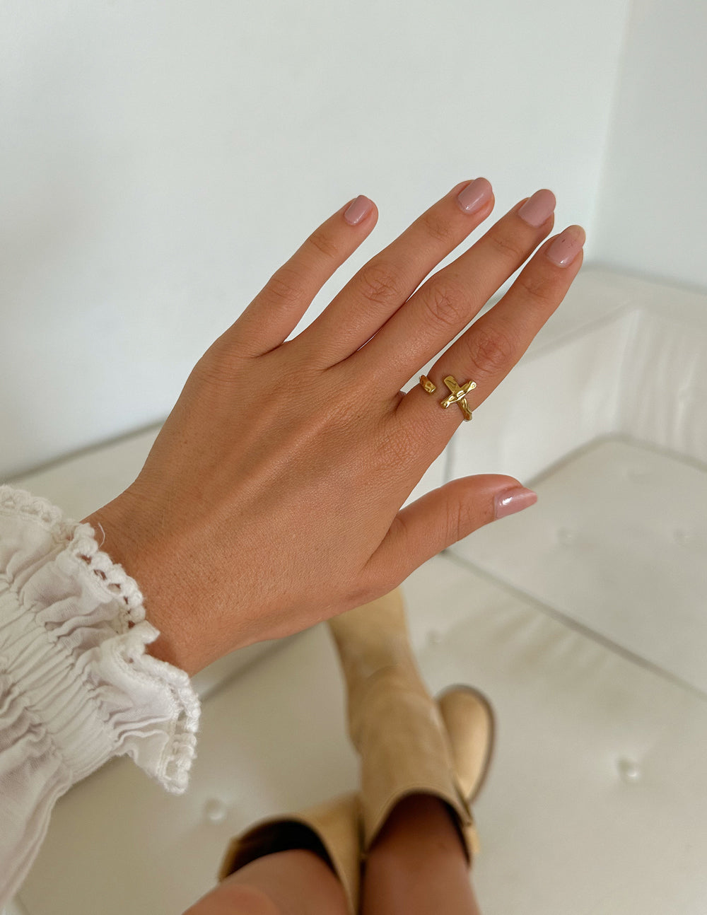 Gold cross ring with wrapped band on finger