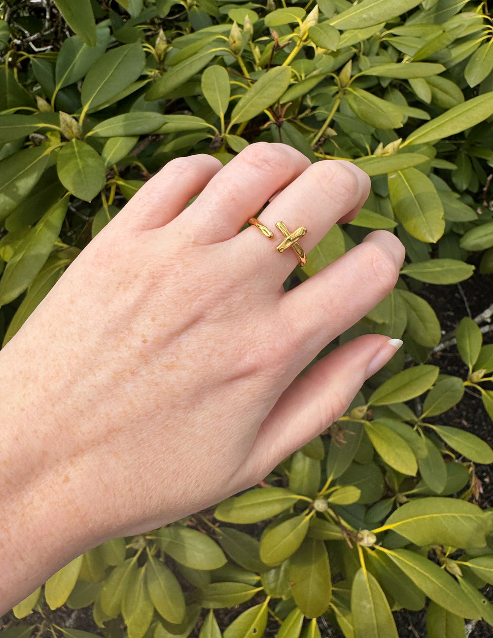 Gold cross ring with wrapped band detail on finger