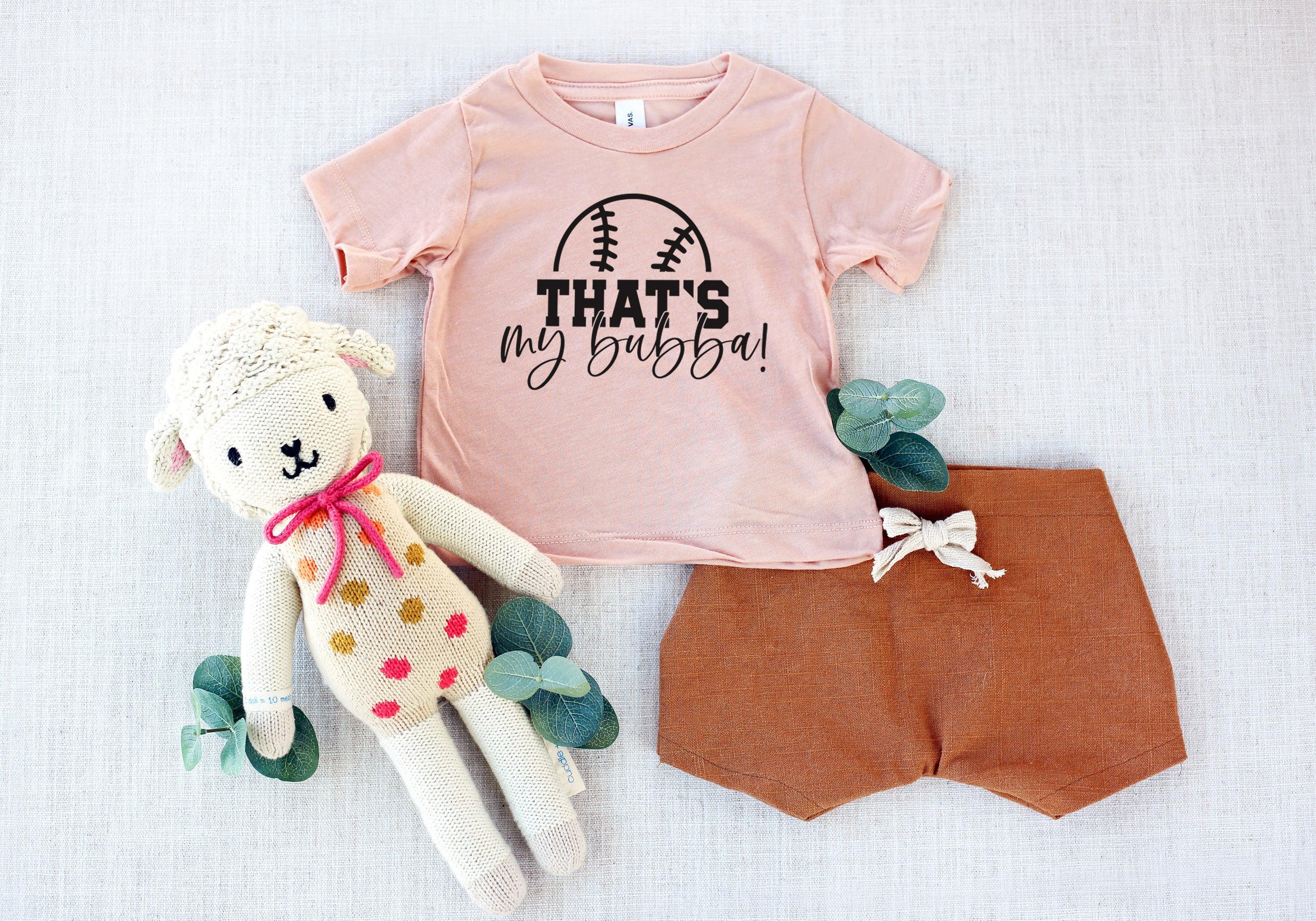 Blush kids graphic T-shirt with football logo and text "THAT'S my bubba!"