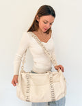Cream canvas duffel bag with side panels and Elevate Faith webbing strap.