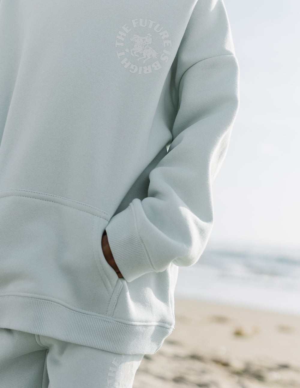 Light mint kids hoodie sleeve and cuff with subtle circular chest graphic