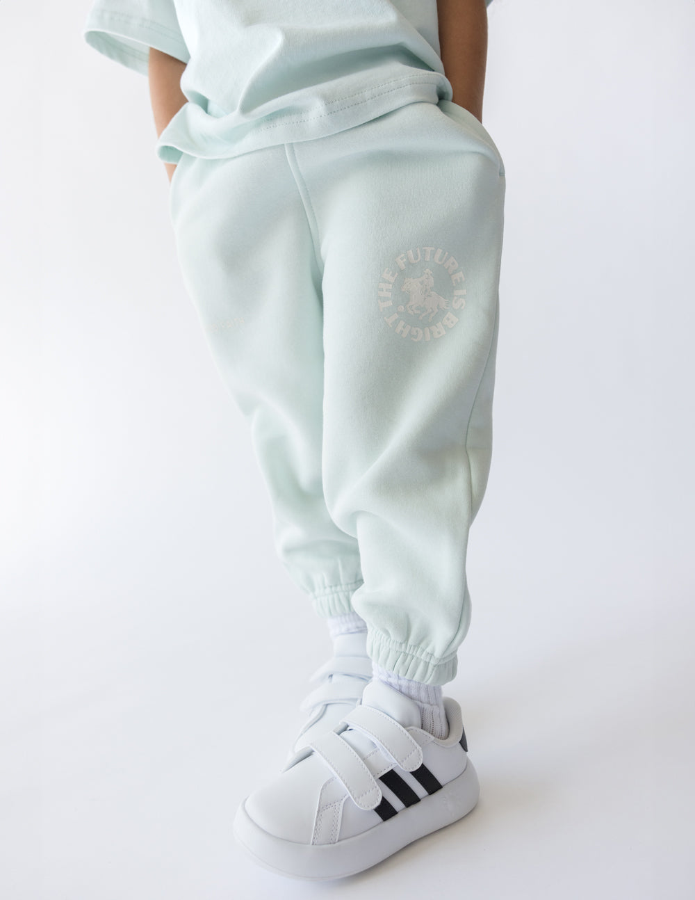 Kids mint sweatpants with elastic cuffs and FUTURE IS BRIGHT graphic on thigh