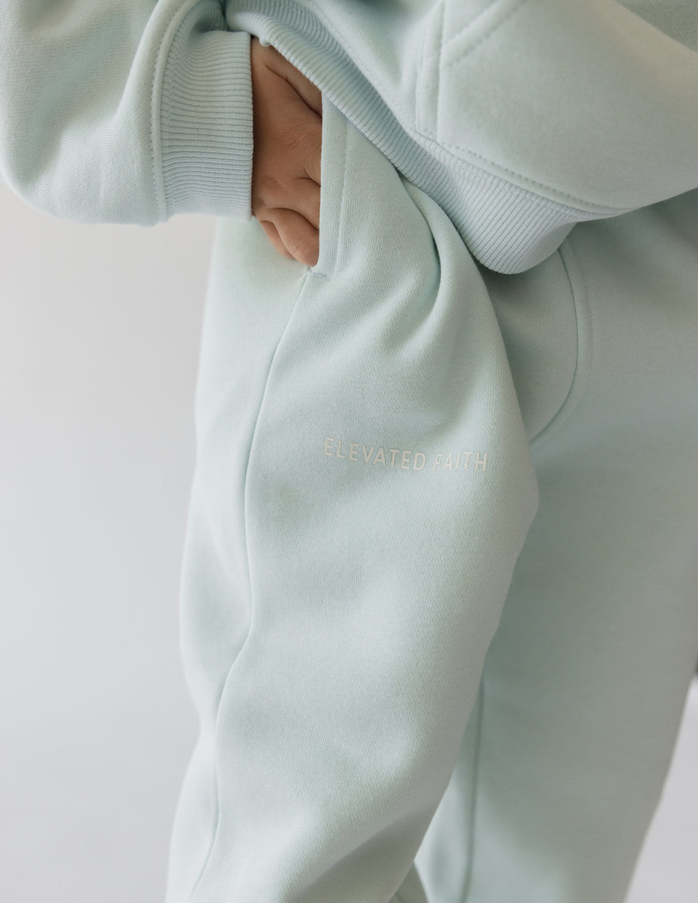 Kids mint sweatpants close-up with ribbed waistband pocket and FUTURE IS BRIGHT logo