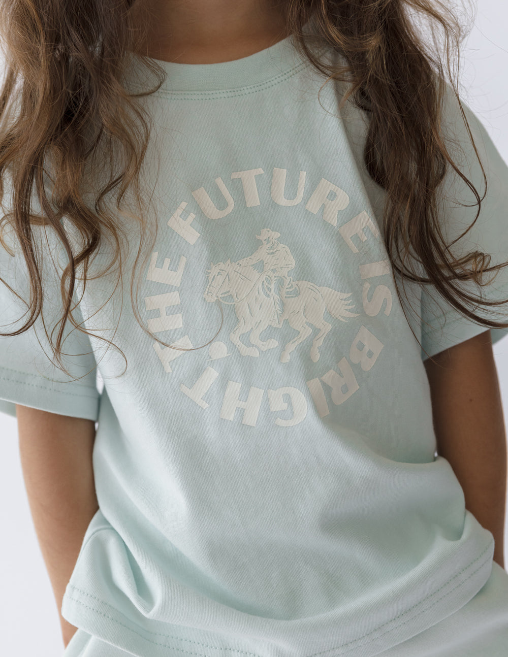 Kids mint T-shirt close-up of the front graphic text and horse illustration in light ink.