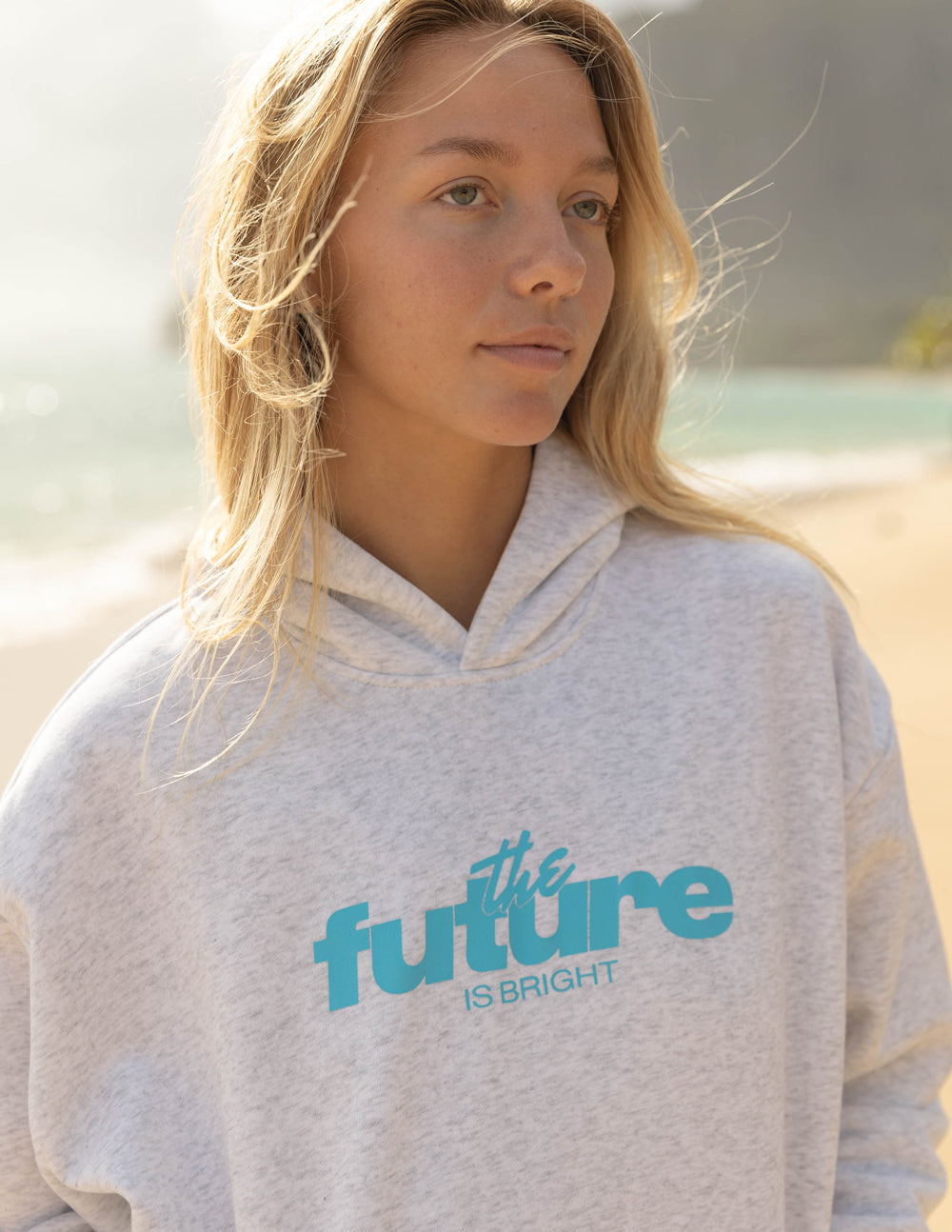 Light gray unisex hoodie close-up, teal 'future' style logo text on chest