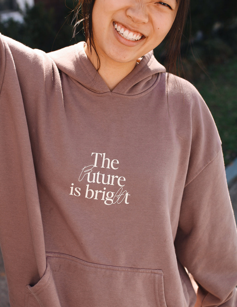 Unisex mauve hoodie close-up with hood and 'The Future is bright' chest print.