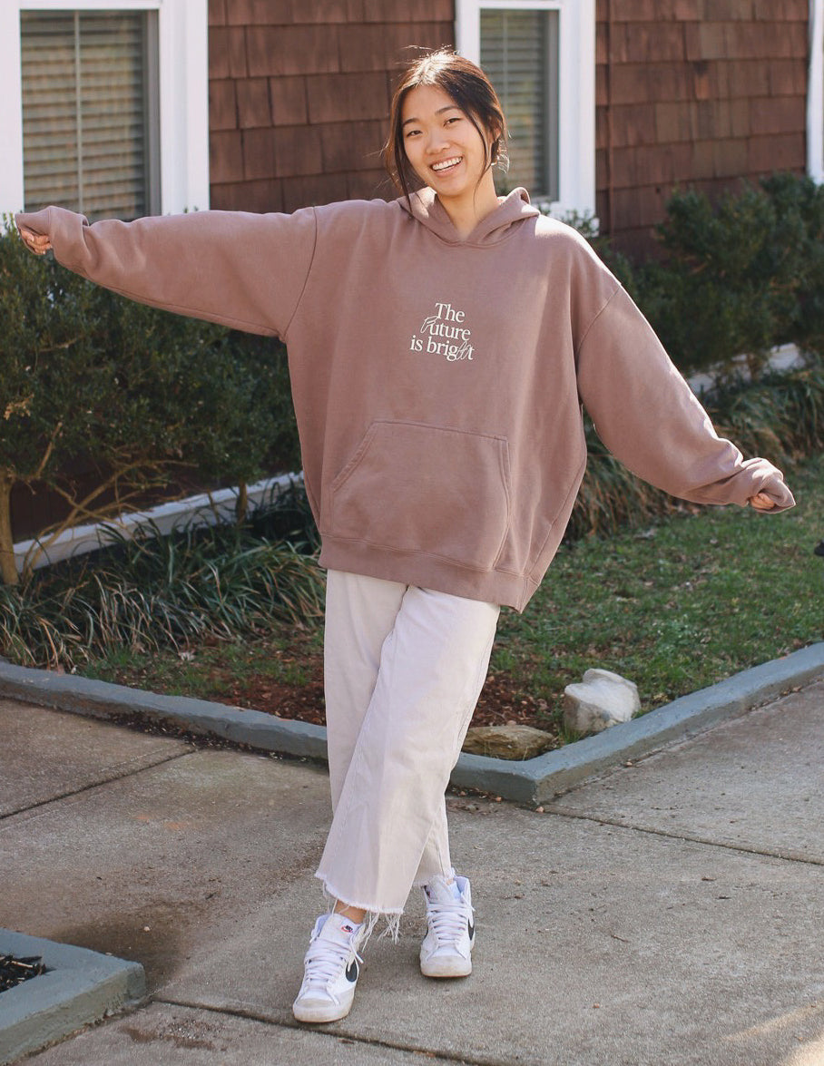 Unisex mauve hoodie with front pocket and hood; 'The Future is bright' graphic.