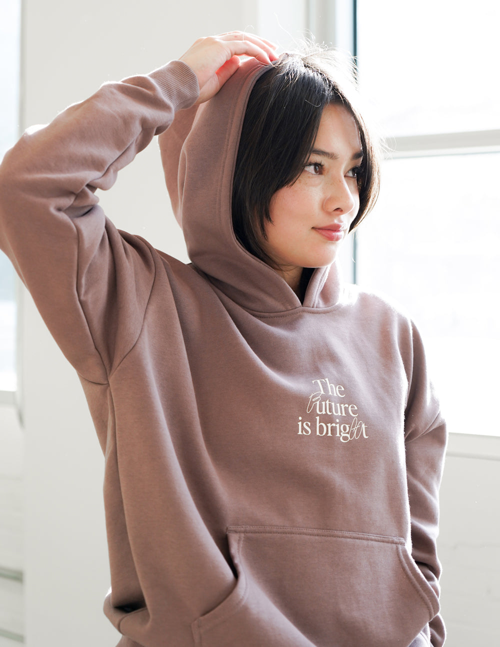 Mauve unisex hoodie with hood up; 'The Future is bright' chest graphic.