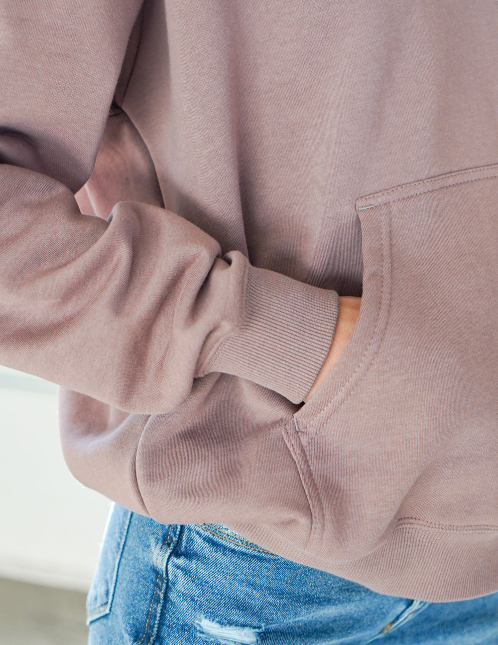 Mauve hoodie sleeve cuff and hem with knit ribbing and stitched seam.