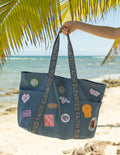 Denim tote bag with colorful embroidered patches and top handles