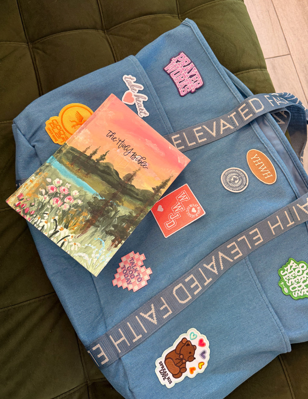 Blue denim tote bag with patches, postcard cards, and small embroidered icons
