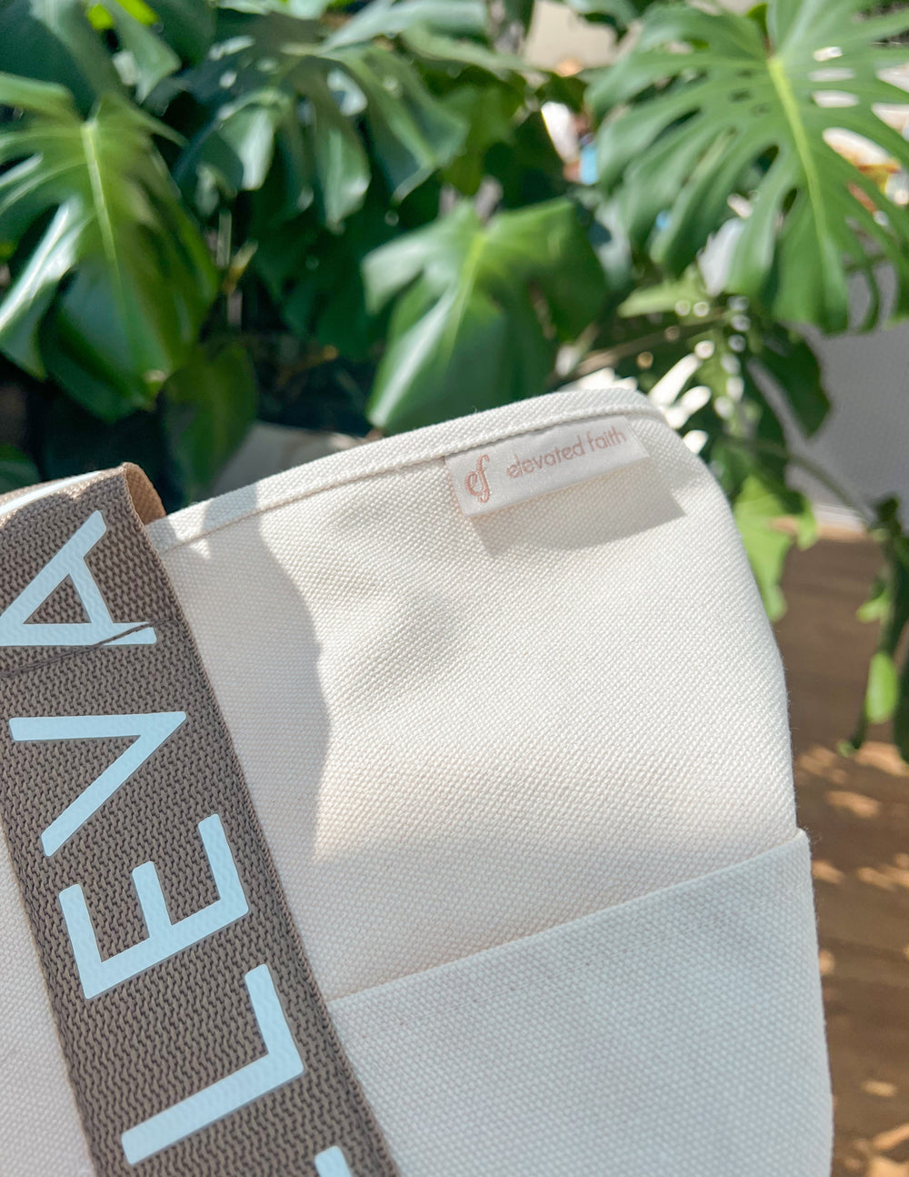 Large everyday tote close-up of brown logo stripe on cream canvas fabric