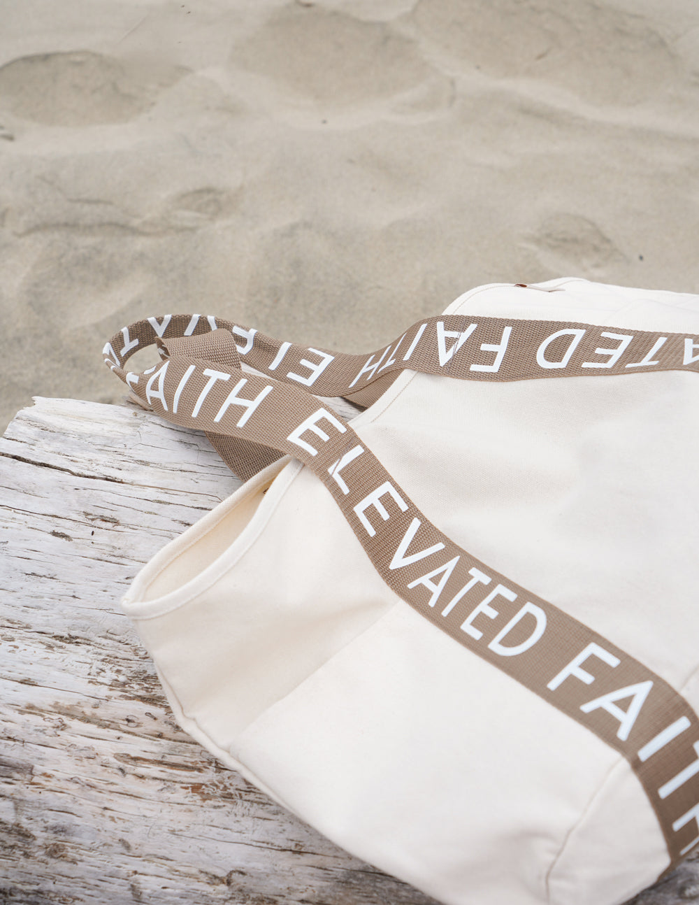 Large everyday tote with overlaid brown logo strap, cream canvas, open top