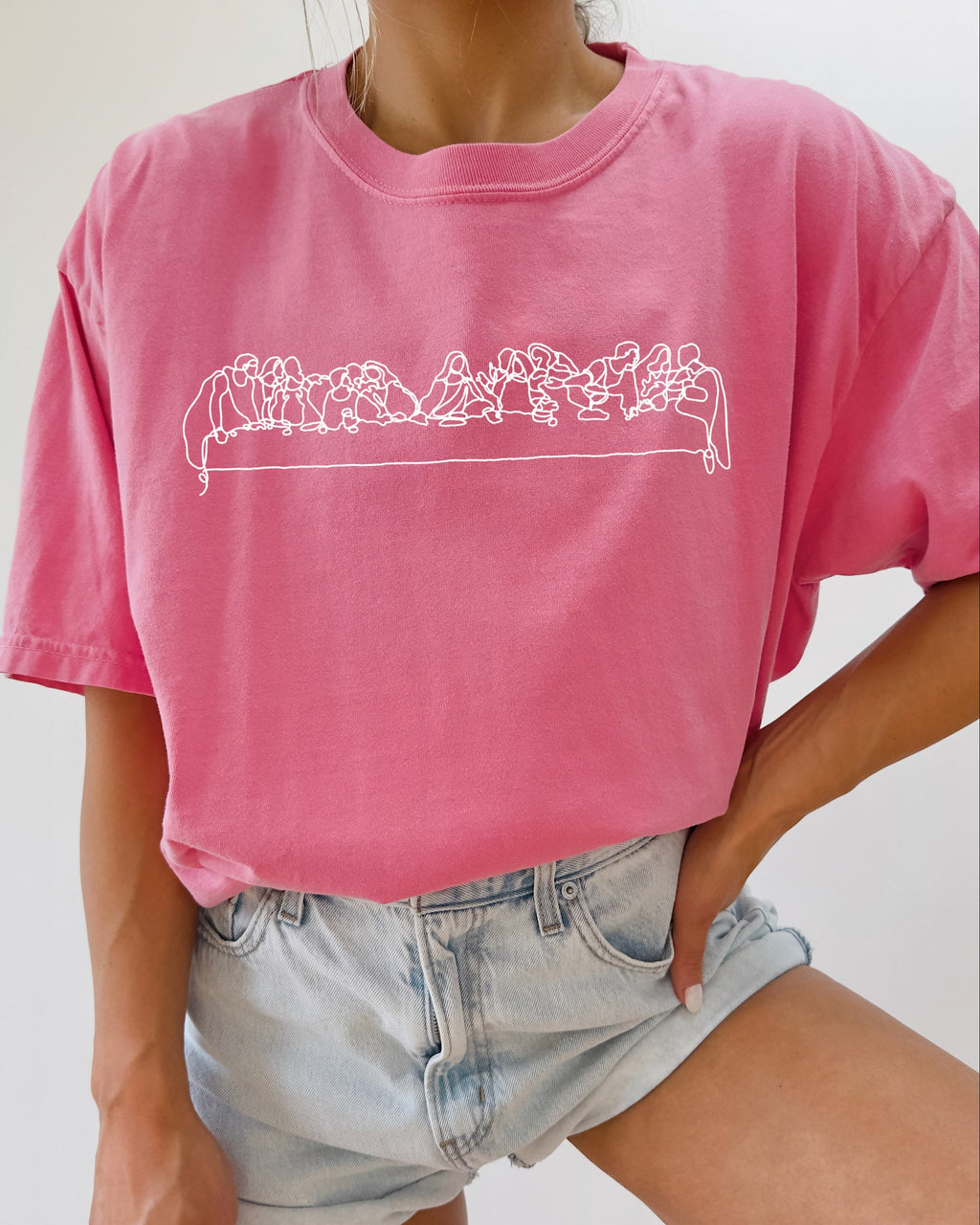 Unisex pink T-shirt with white line Christian scene graphic across chest