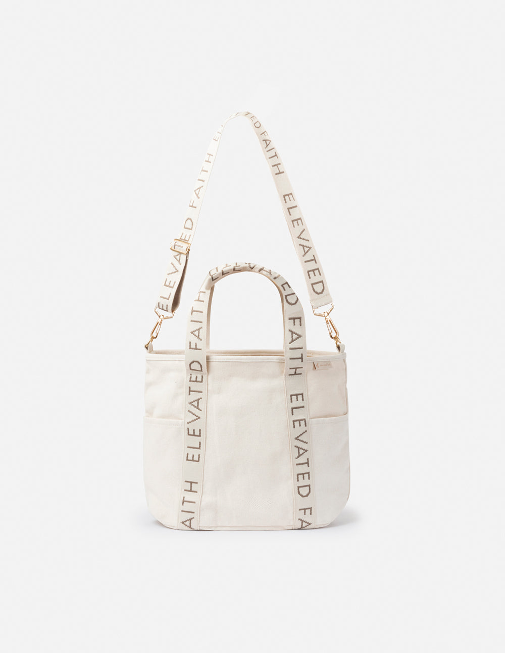 Cream mini tote with short top handles, open top, and “ELEVATED FAITH” printed trim