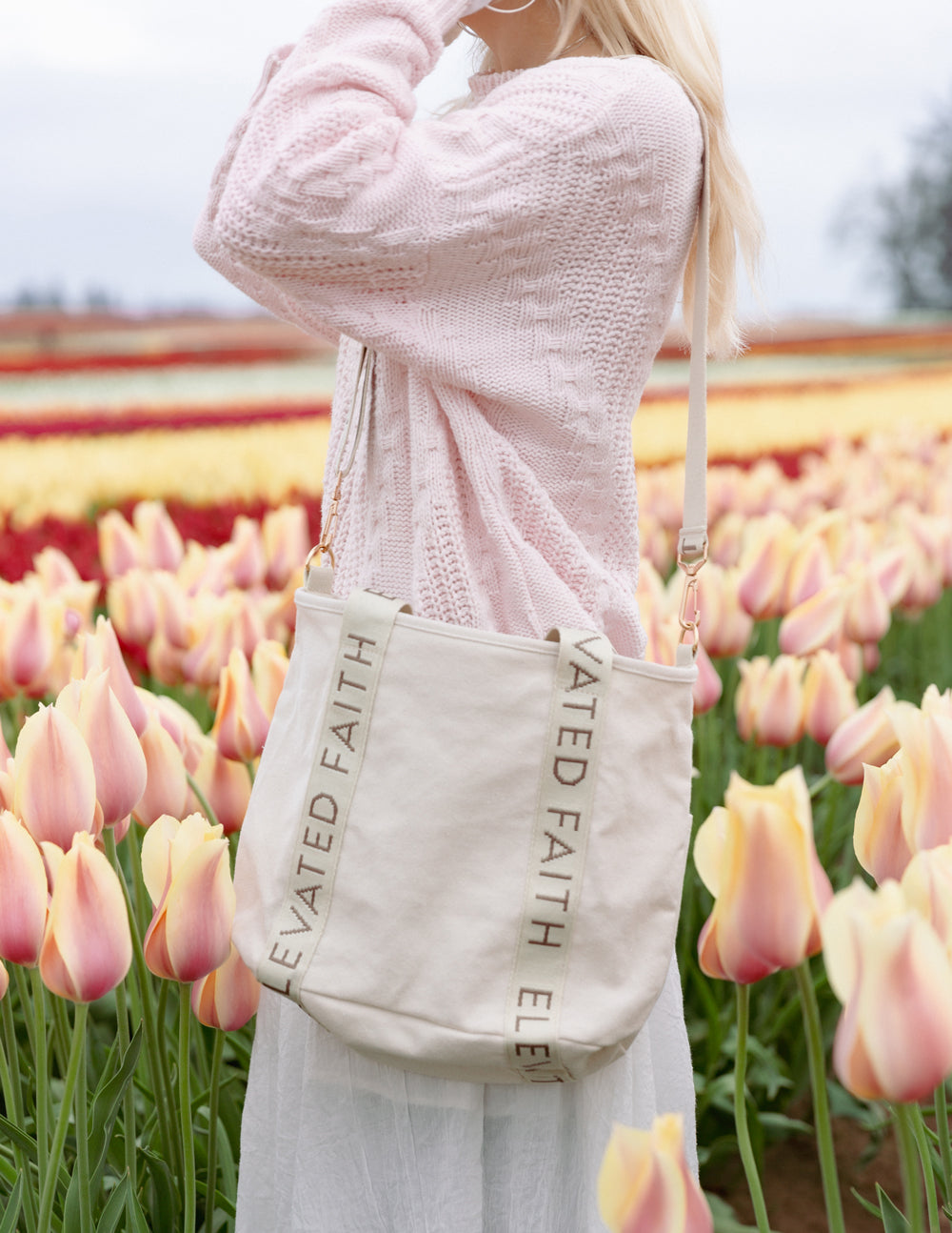 Cream mini tote bag with wide strap and “ELEVATED FAITH” printed band