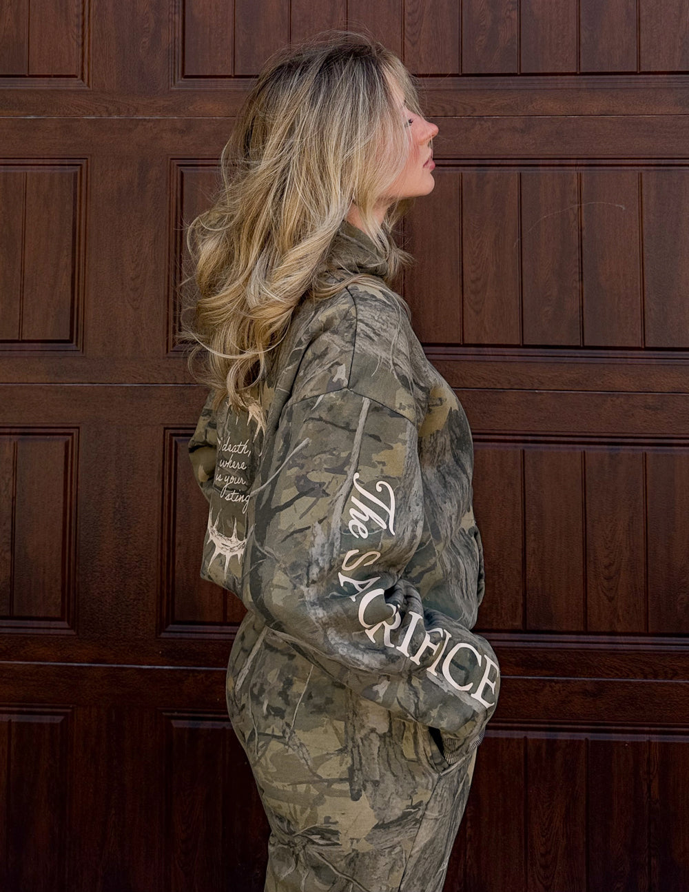 Camouflage unisex hoodie with back hood and large “Sacrifice” sleeve lettering