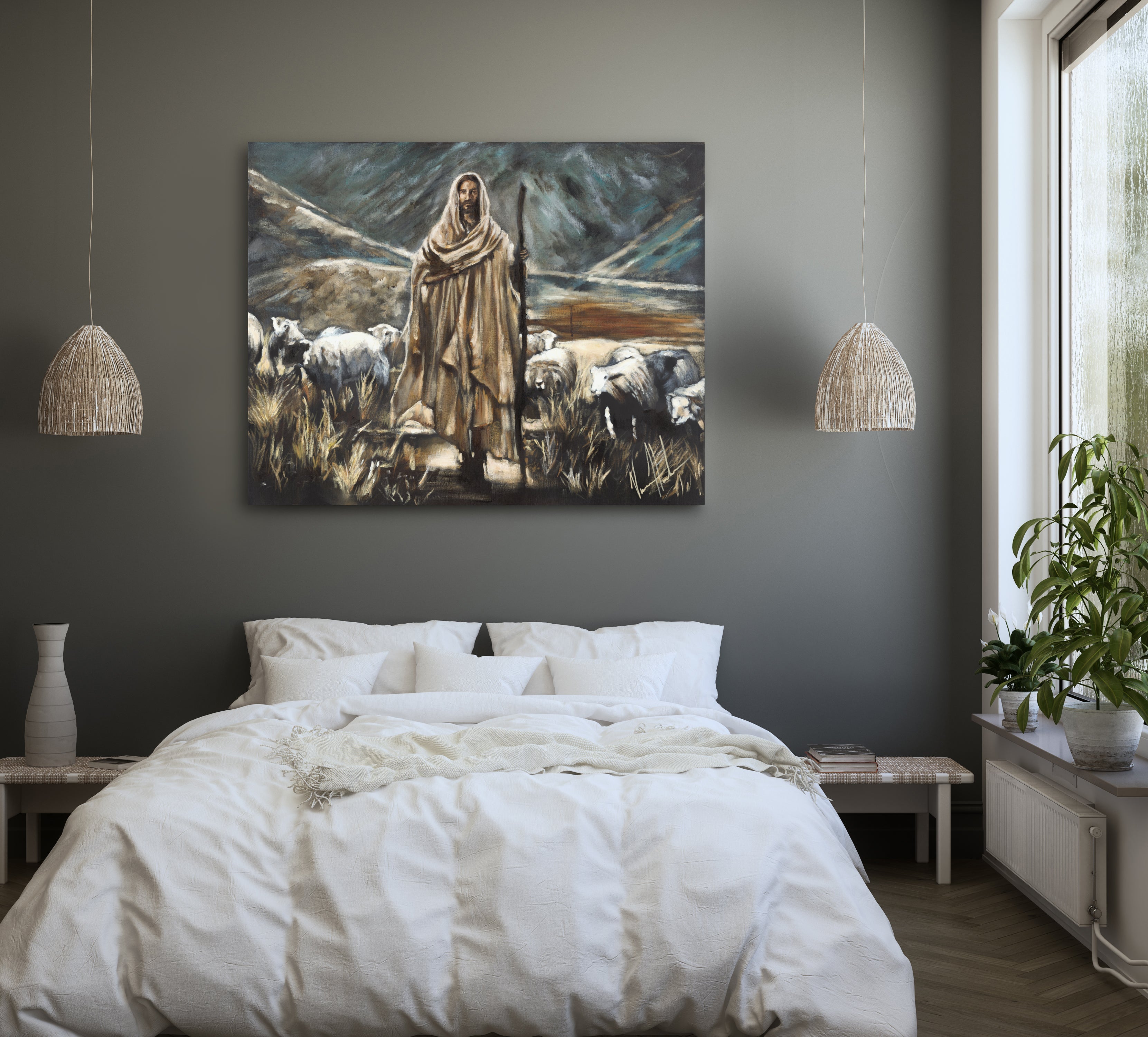 Framed wall art of robed shepherd and sheep in a field, shown above bedding