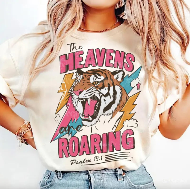White tee with roaring tiger graphic, 'Heavens' headline and Psalm 19:1 print