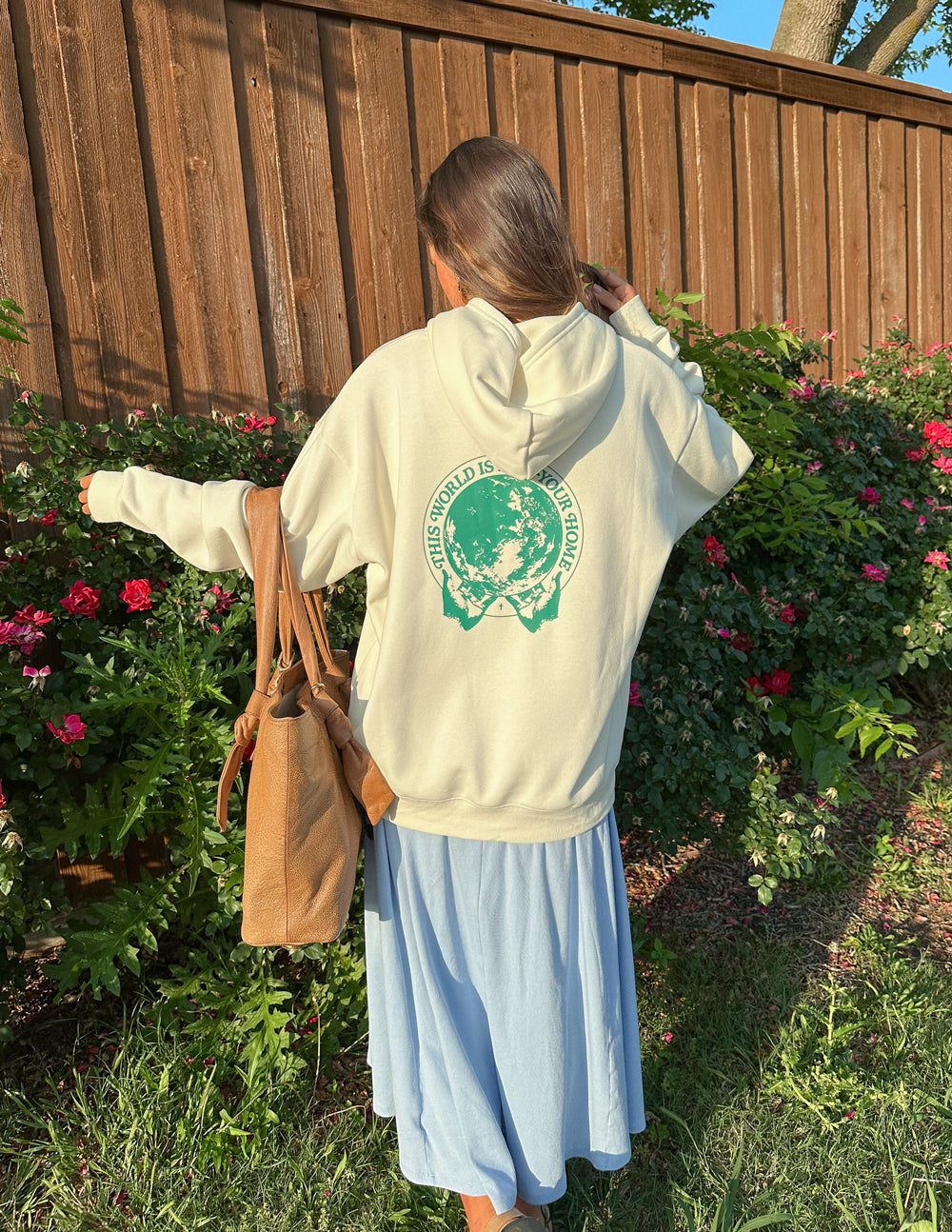Light cream unisex hoodie on model with green back graphic and hood