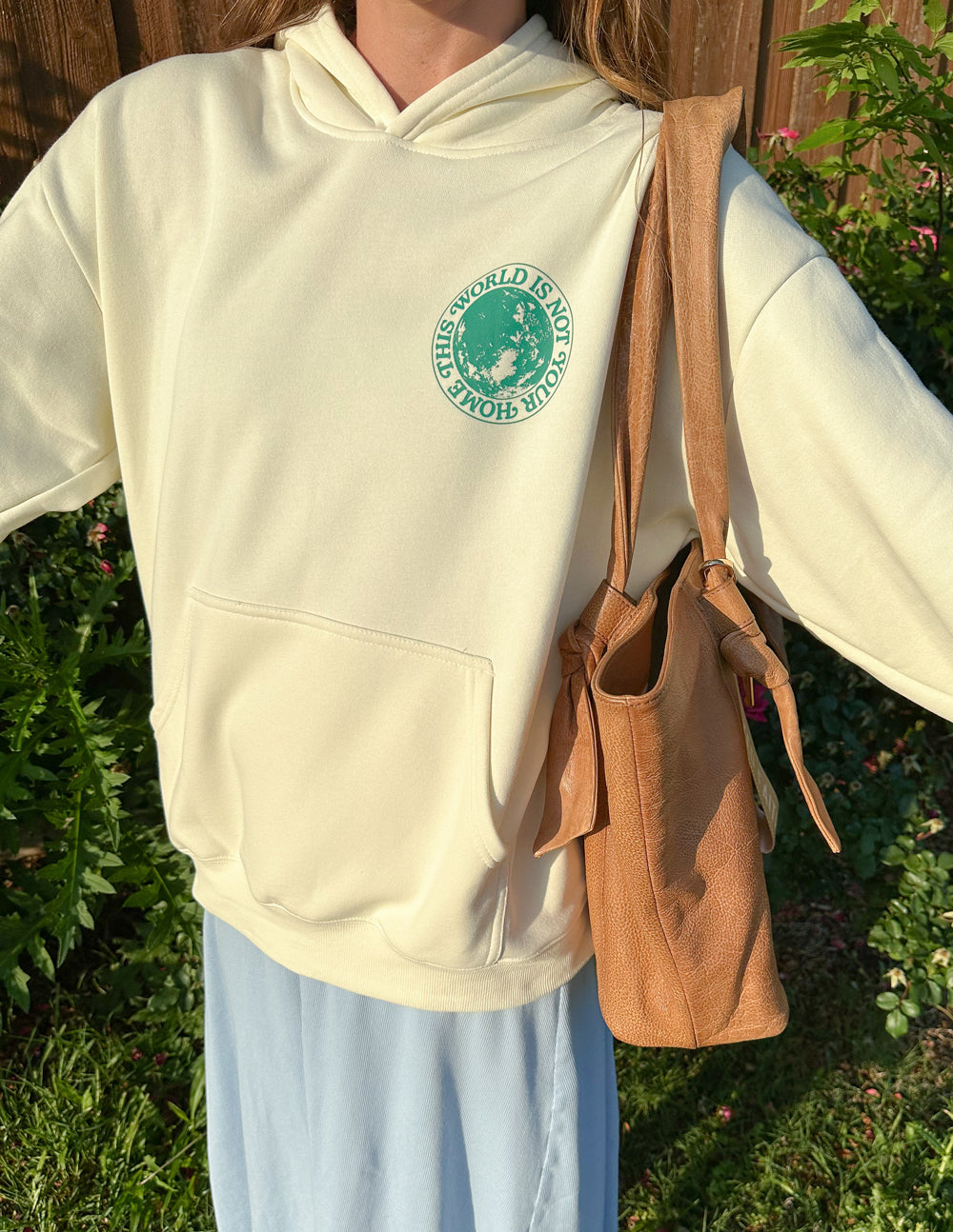 Light cream unisex hoodie with green chest logo and front kangaroo pocket