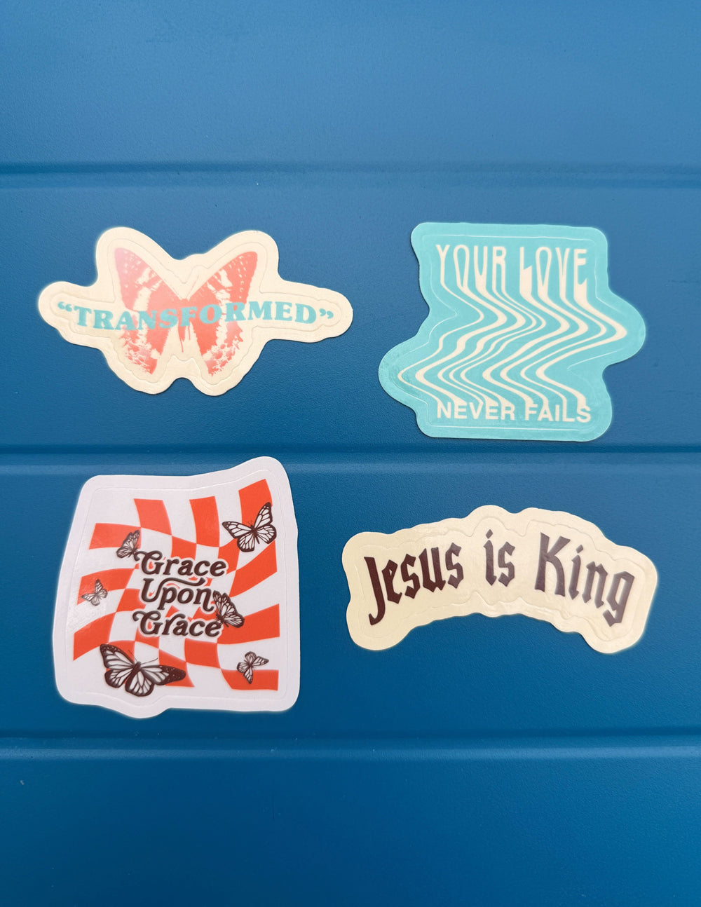 Sticker set on blue: TRANSFORMED, Grace Upon Grace, Jesus is King, Your Love Never Fails