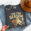 Black crewneck T-shirt with “Tis the Season” Halloween graphic; floral neckline detail