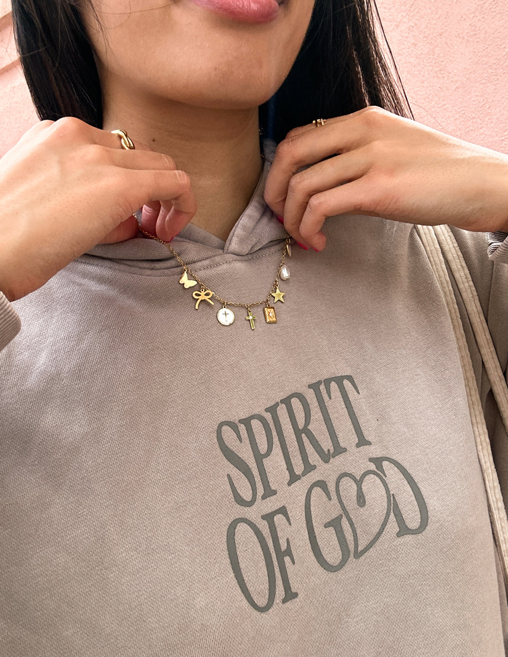 Gold-tone charm necklace with star and heart charms, layered on collar