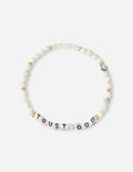 White beaded letter bracelet with gold accents and "TRUST GOD" charm beads