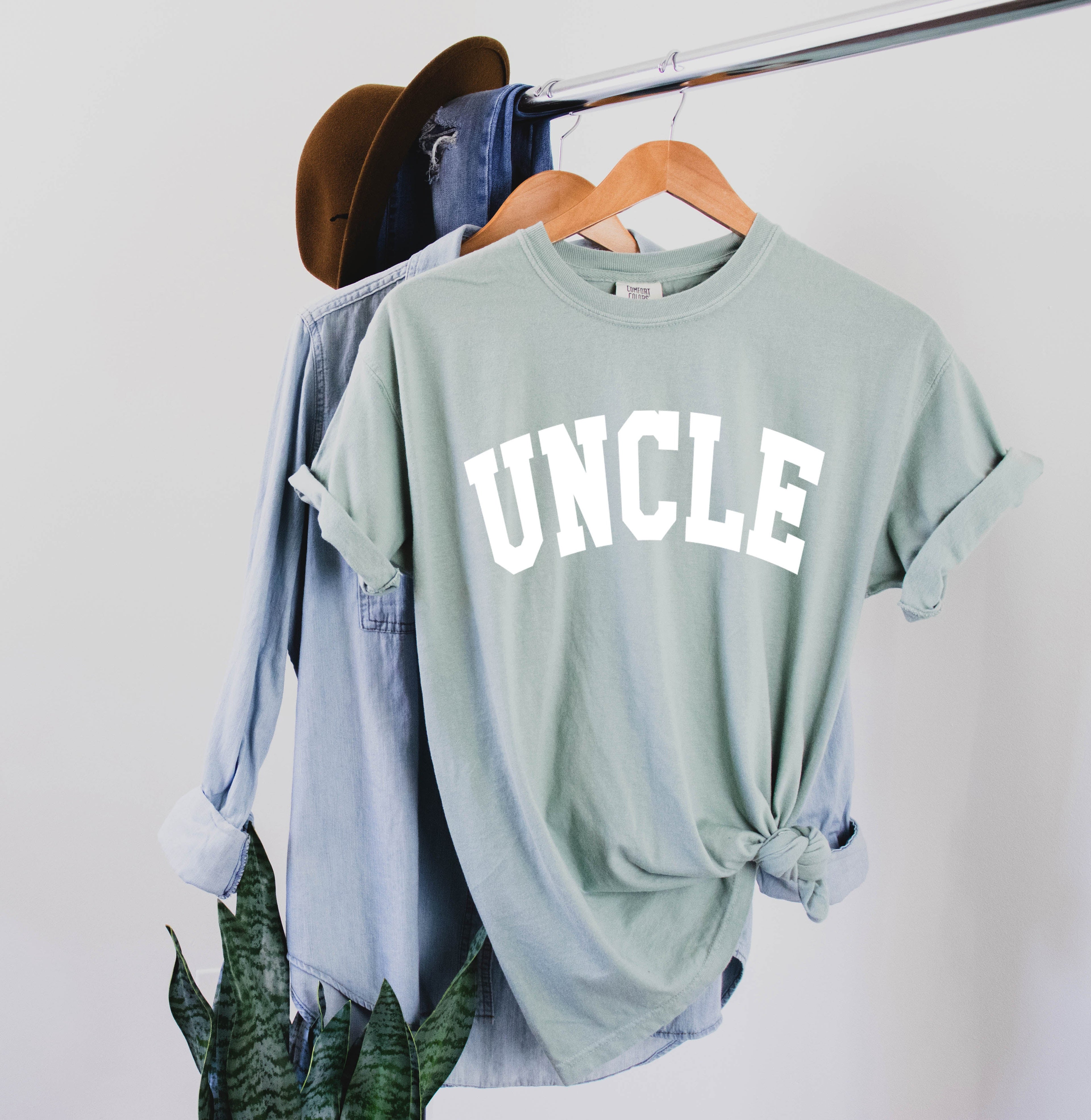 Light mint T-shirt with large white “UNCLE” graphic on the chest.