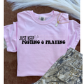 Pink graphic tee with 'Just Keep Posting & Praying' print