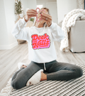 White holiday sweatshirt with colorful 'Deck the Halls' front graphic and long sleeves.