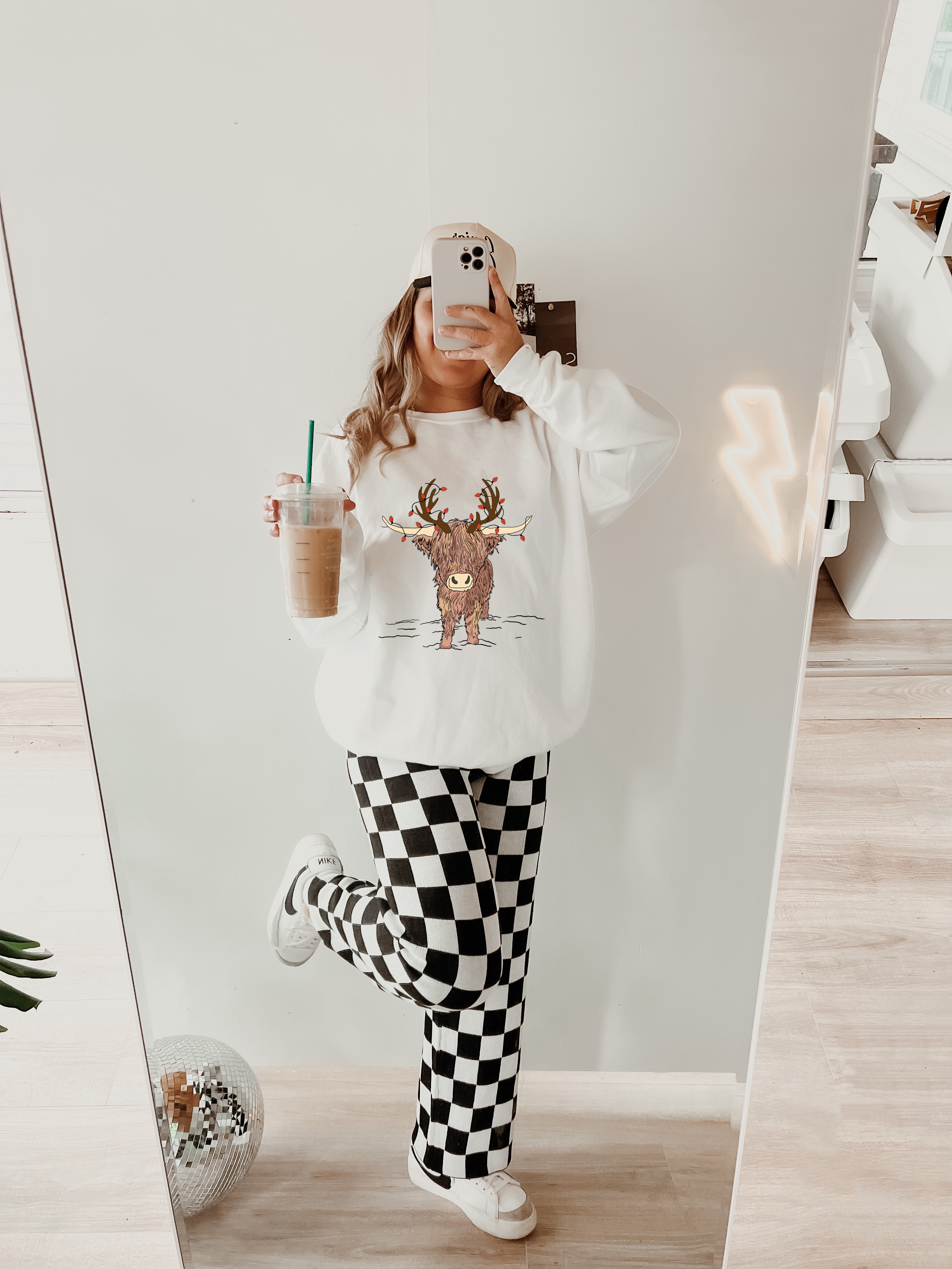 White sweatshirt with Christmas lights Highland cow reindeer graphic