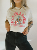 Retro holiday graphic tee, white with red tree and marching reindeer print