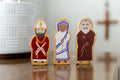 Religious wooden peg figure set with three standing characters, painted robes and halos